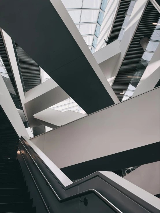 the escalator inside of a building with high ceiling and skylight