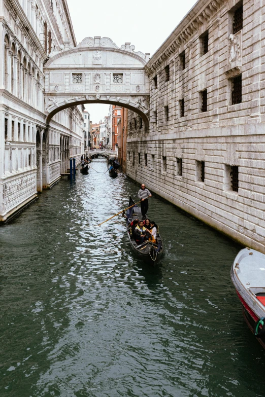 boats pass under the arch of a bridge in venice