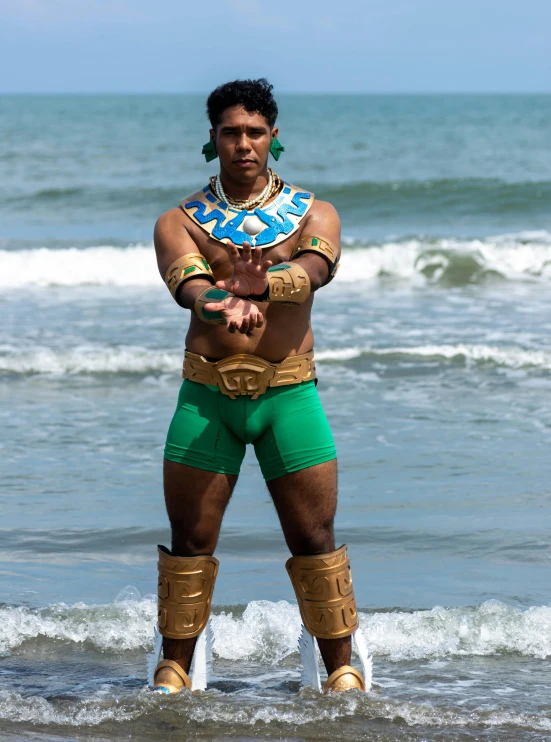 a man dressed in green trunks standing on the beach