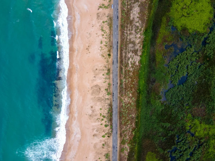 an overhead view of a tropical beach and road next to the ocean