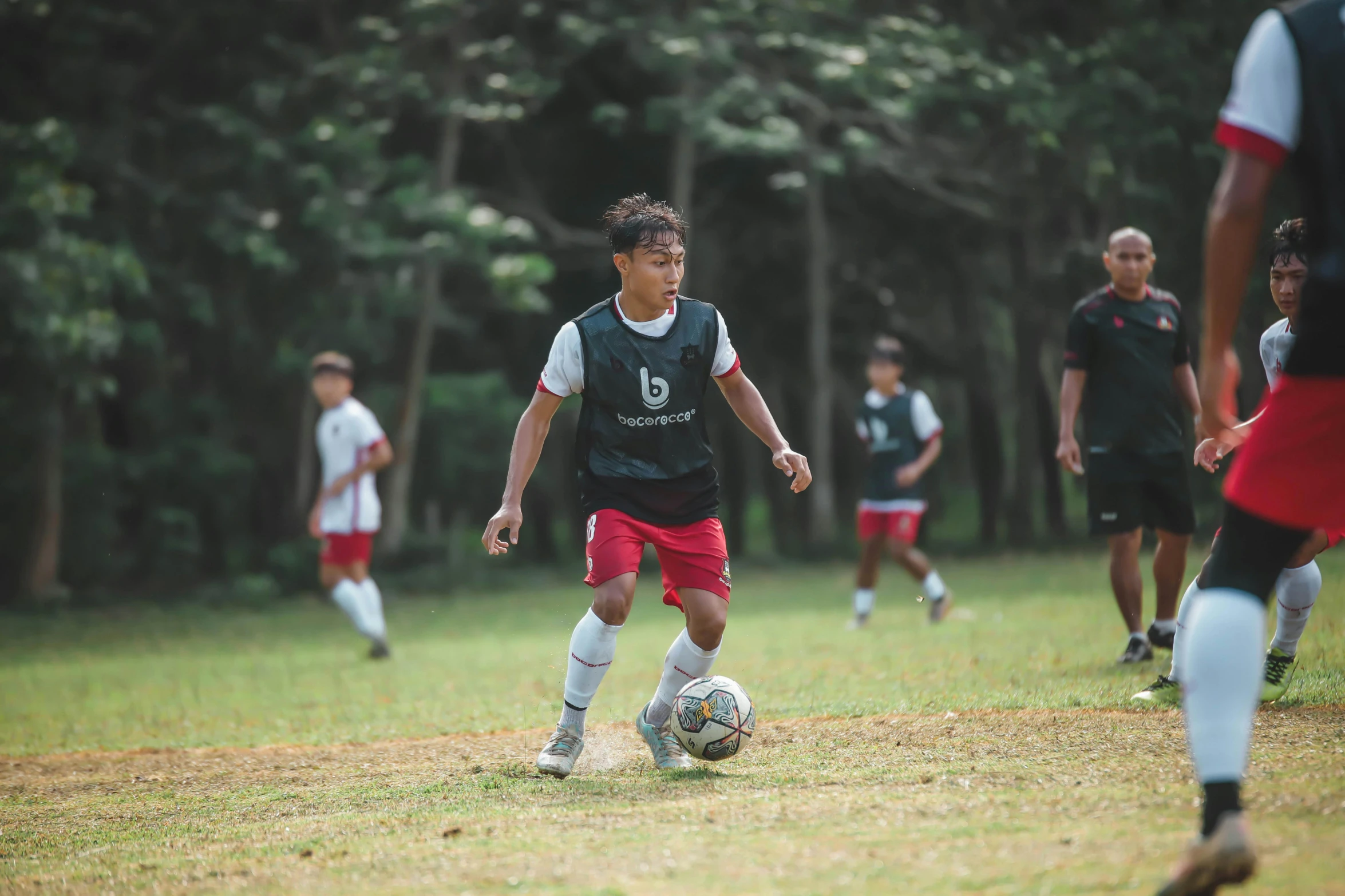 boys play soccer while others watch