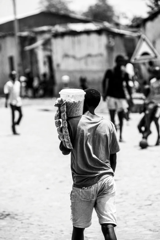 a man walking down the street while holding a large cup