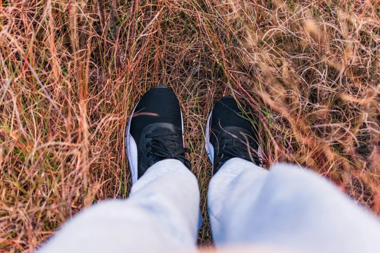 someone standing in a field with their feet crossed