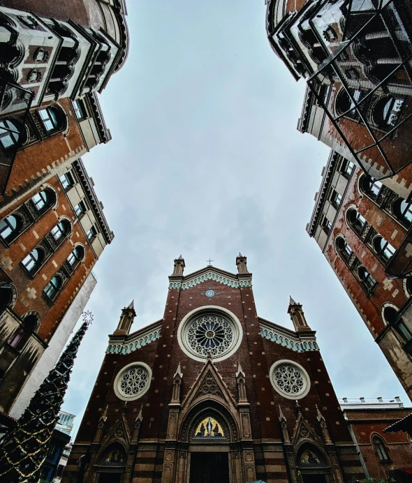 looking up at a building with two clocks on each of it's sides