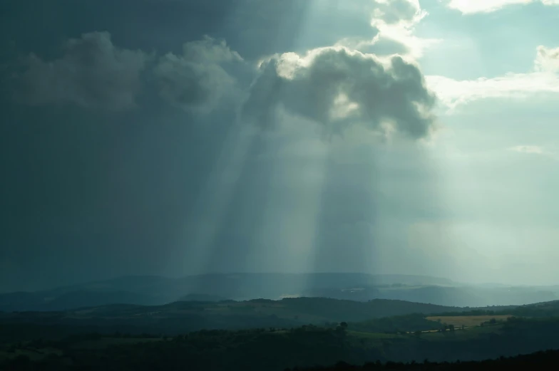 rays break from behind clouds in the sky