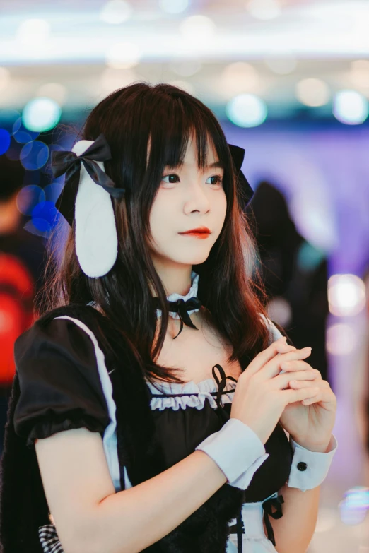 a young lady with an asian style wig wearing a black and white outfit