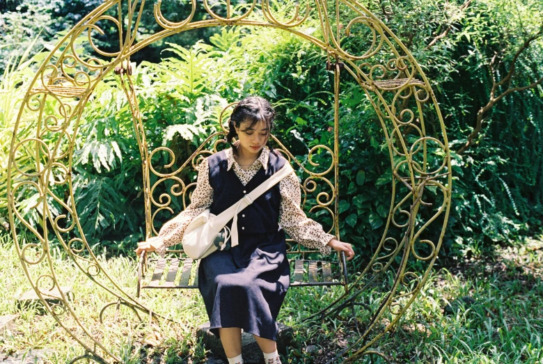 a person holding a guitar on a bench in the grass