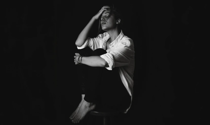 a man sitting on top of a stool next to a wall