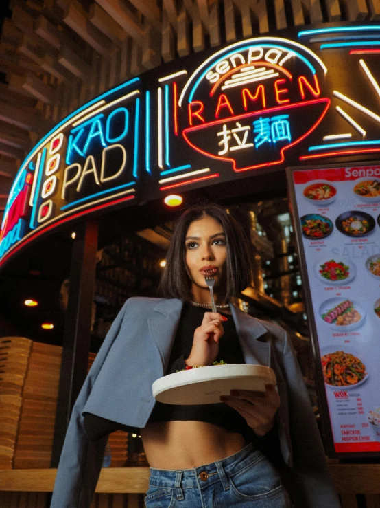 a woman with her dog in front of the ramen restaurant sign