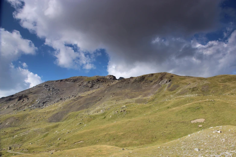 the side of a green mountain, with sp vegetation on it