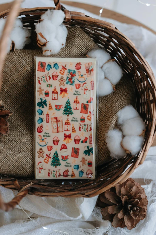 a basket filled with cotton next to a notepad and a pine cone