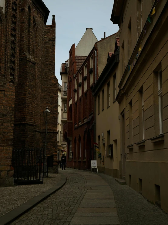 a man walking down an alleyway between buildings