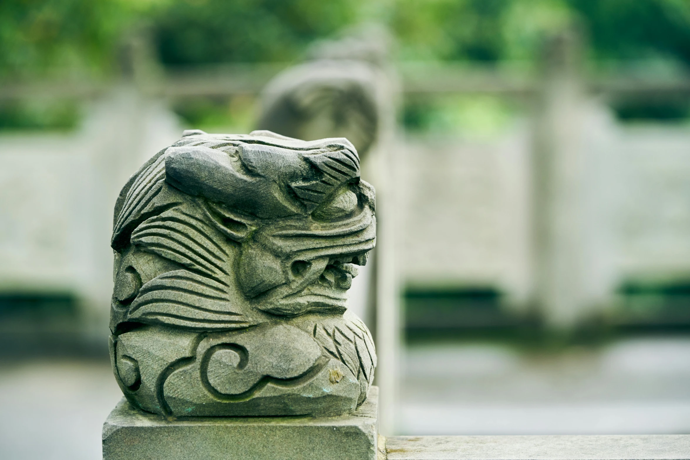 a stone gargoyle statue is displayed in an outdoor area