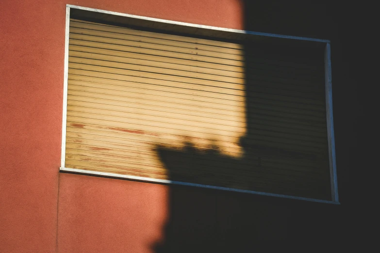 a shadow of a shadow of a hand and the side of a building