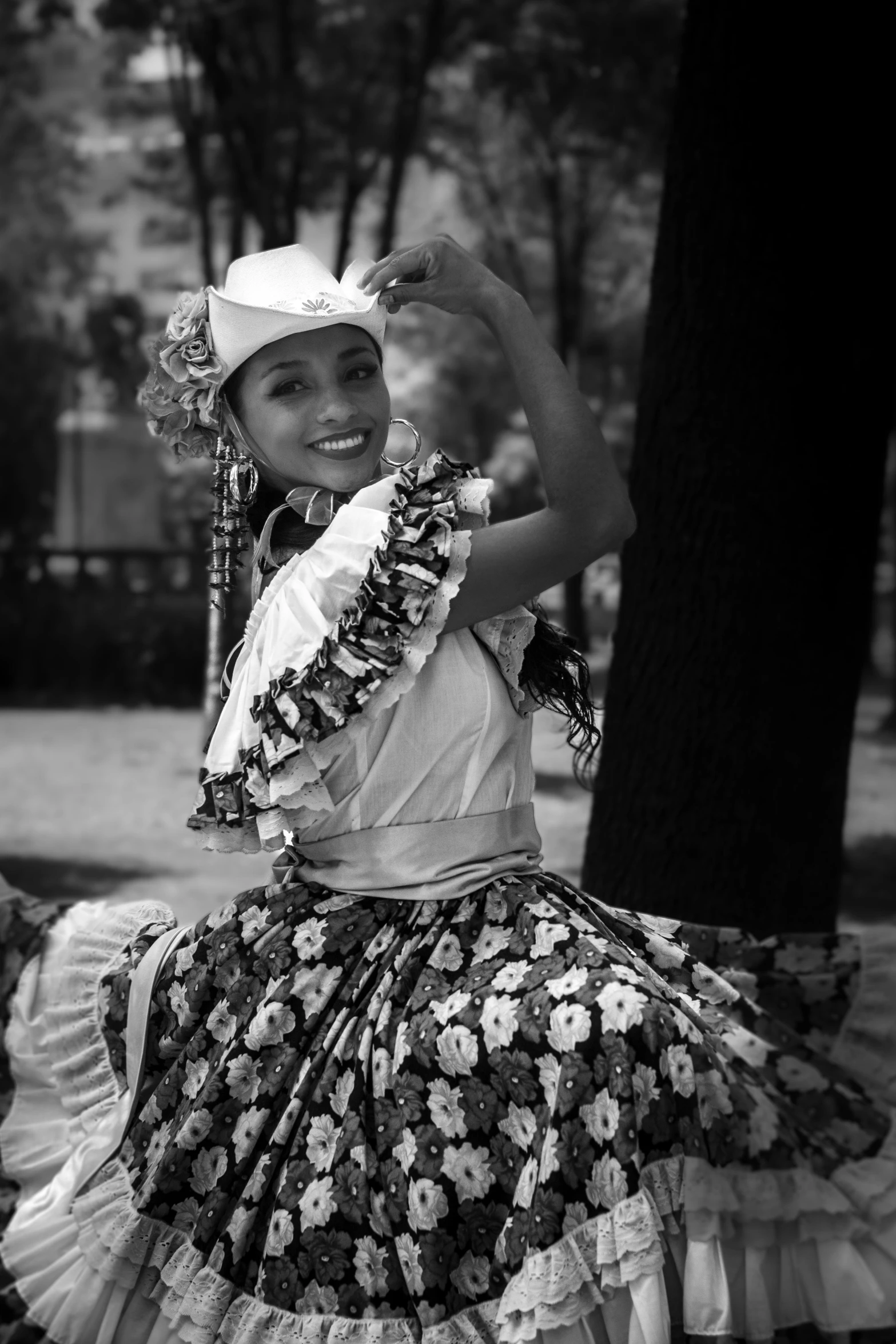 a woman in a dress is dancing next to a tree