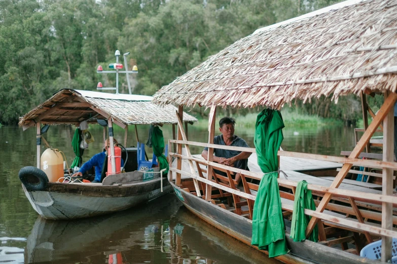 there are two boats with people on them and some grass umbrellas