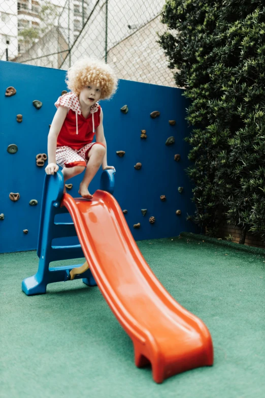 a little  playing on a playground slide