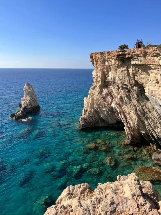 a rocky shoreline with blue water next to rocks