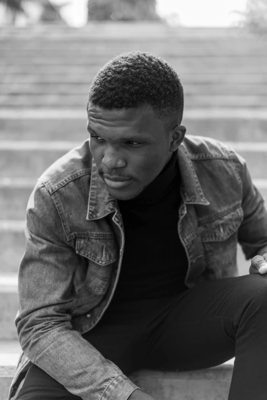 a young man leaning against stairs holding his hands out