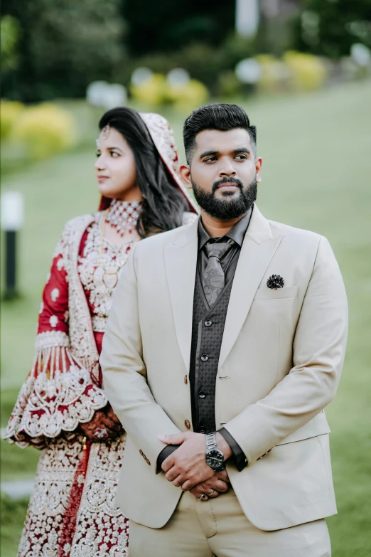 man standing next to his wife while dressed in a suit