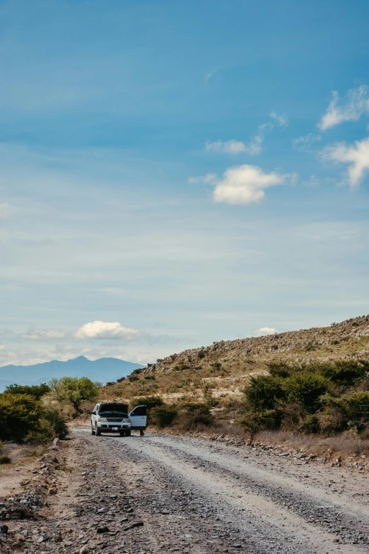 a truck on the side of a dirt road