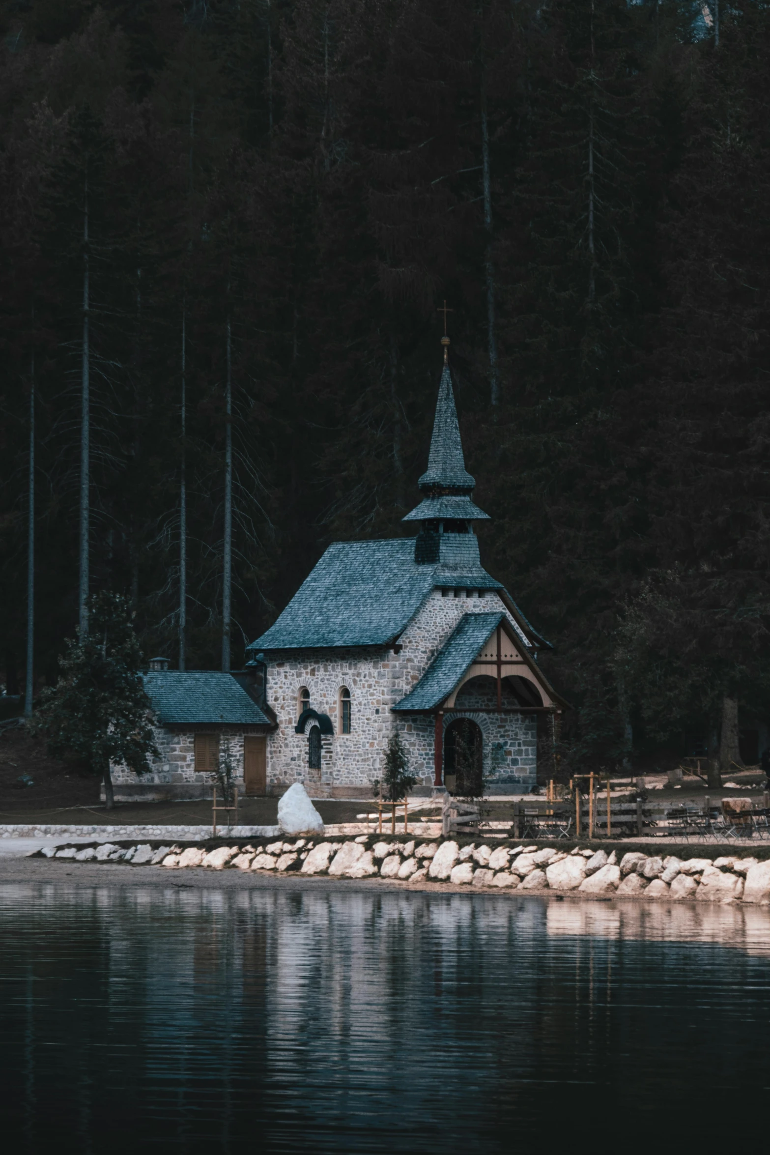 a church sits on the shore of a lake