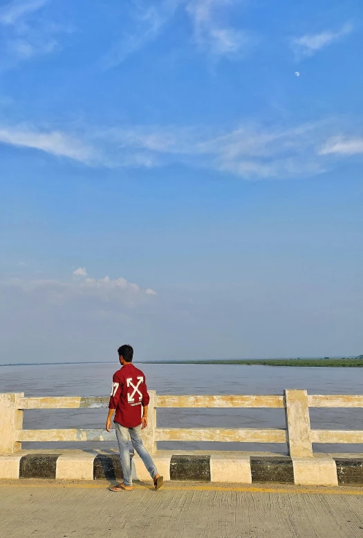 a person in a red shirt is flying a kite