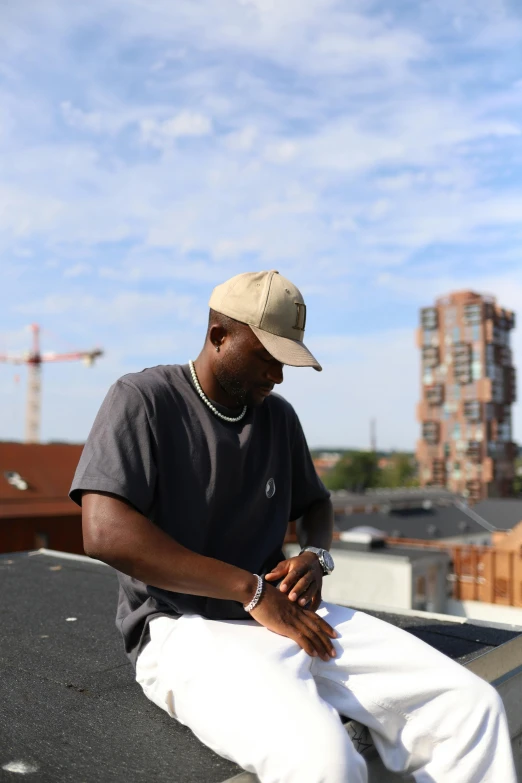 man sitting on the roof using his phone