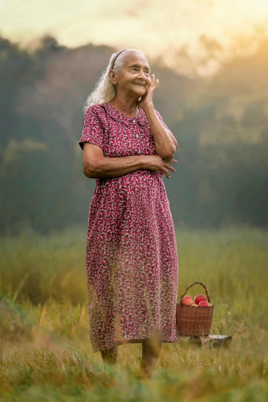 an old woman standing in a field, wearing a red dress and holding a basket