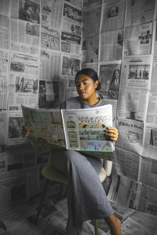 a girl reading a map with lots of newspapers around her