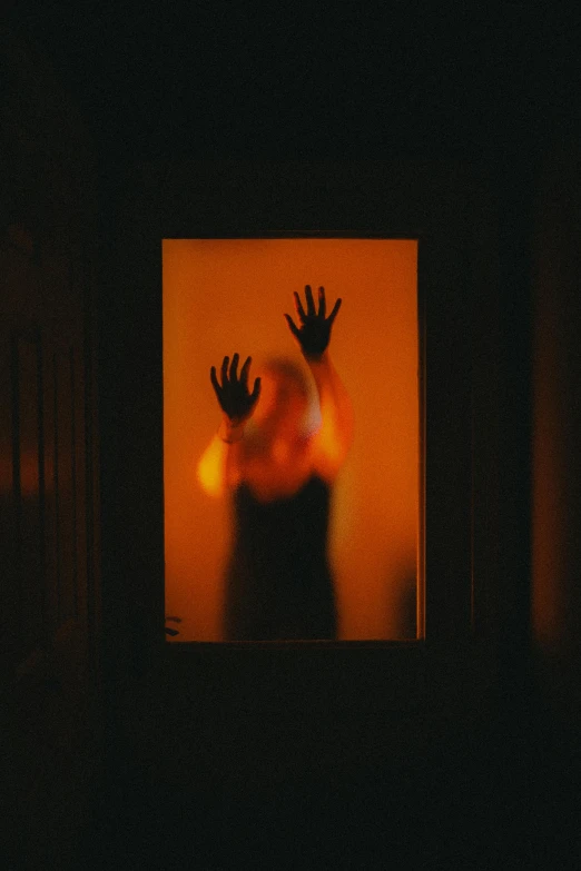a person holding up their hands in front of a mirror