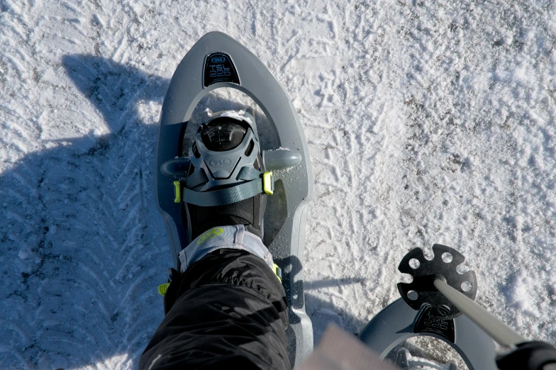 a person riding on top of a snowboard next to another skier