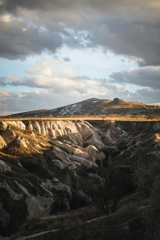 a view of some large rocks and a hill