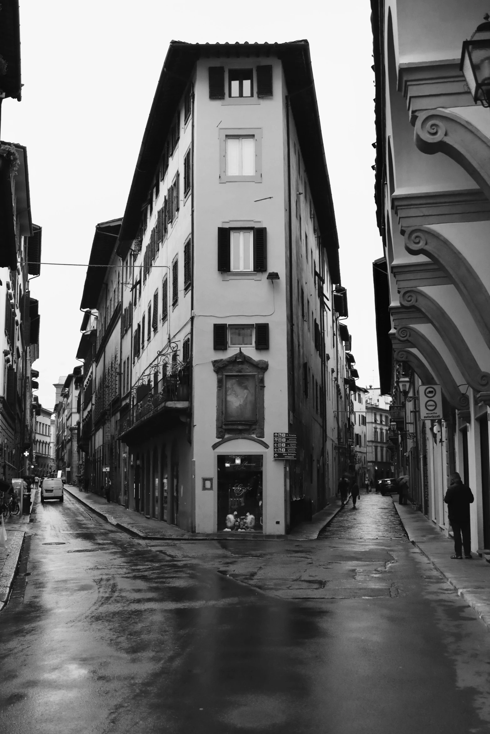 a view of a narrow city street in the rain