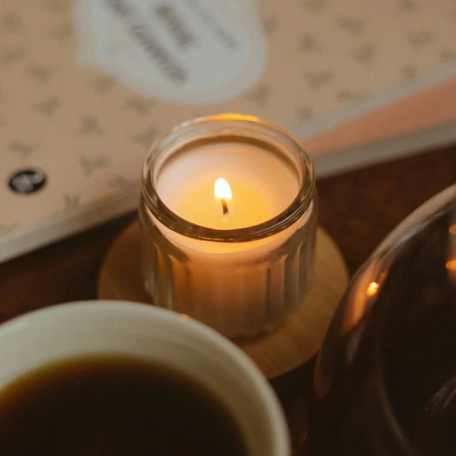 the candle is next to a cup of tea