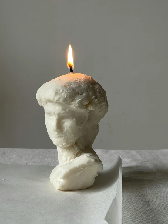 a candle that looks like a white plaster sculpture