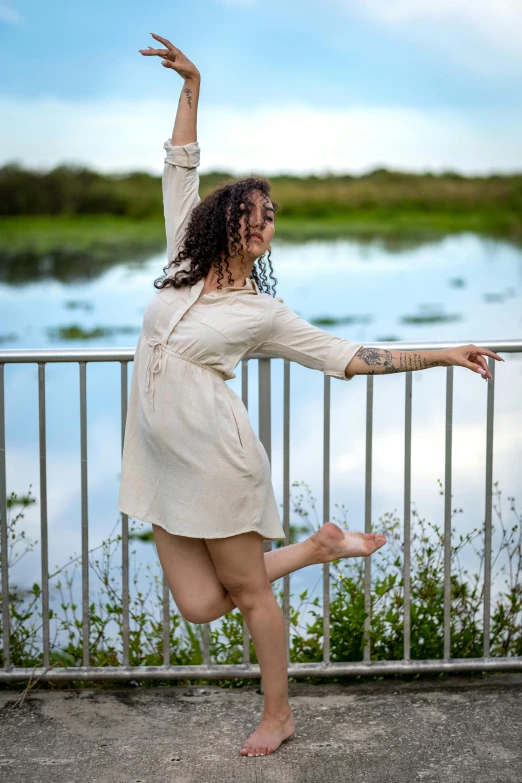 a woman that is standing on one leg and making an open hand gesture