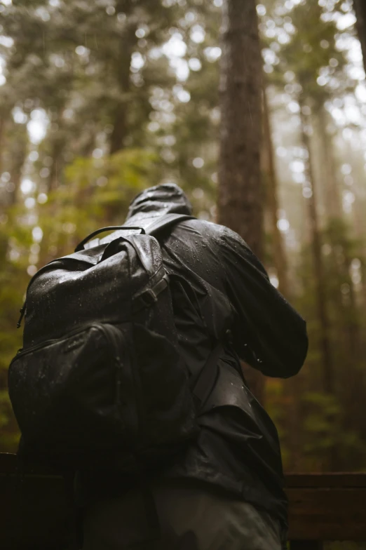 a large black backpack sits on top of a wooden bench