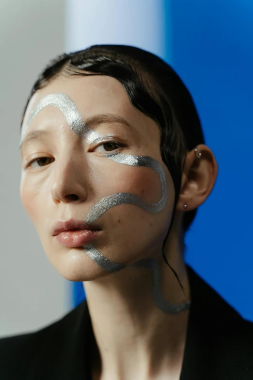 a girl with silver makeup looking at the camera