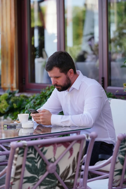 a man sitting at a table with his cellphone
