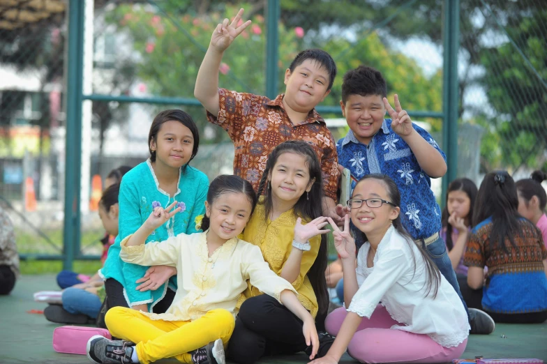 young children are posing for the camera outside