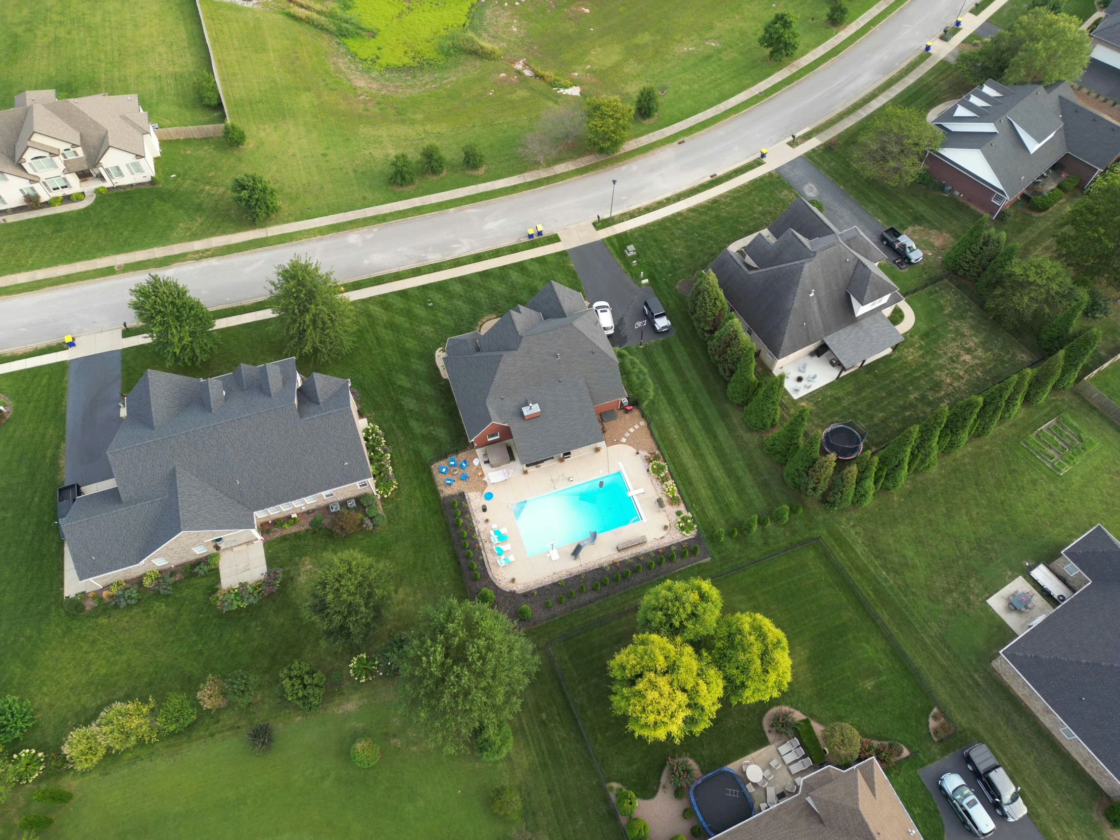 an aerial view shows homes, streets and a pool