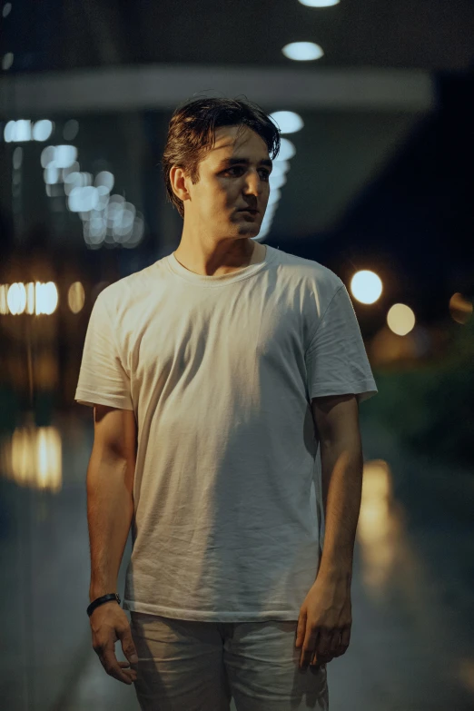 a man wearing a white shirt standing in a hallway