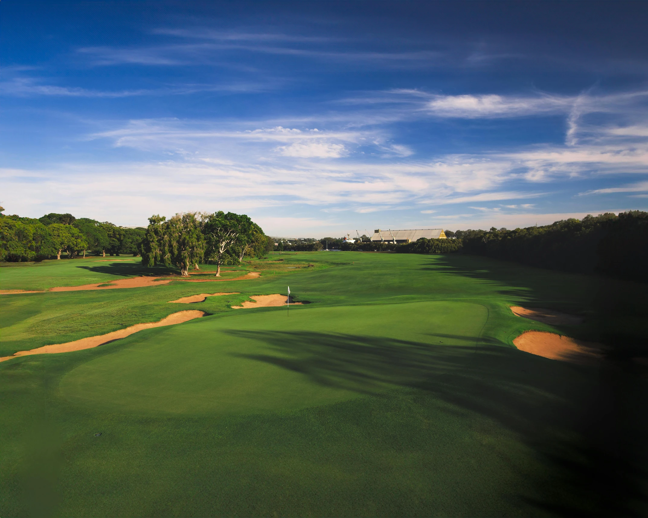 an aerial view of the golf course with green grass and trees in the background