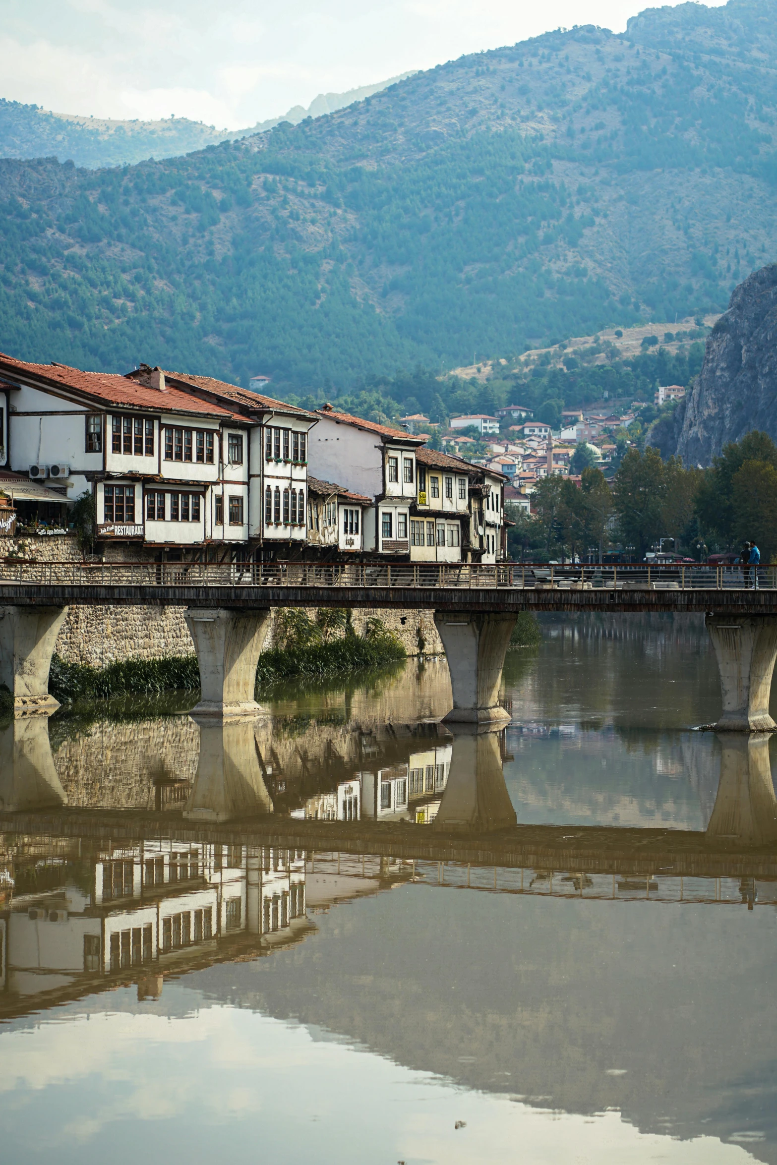 the buildings are next to a bridge that is reflecting in the water