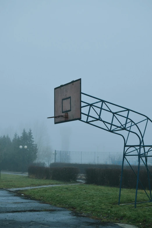 a metal basketball hoop attached to a metal guard in front of a building