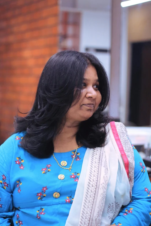 a woman in a blue shirt and a white and red sari