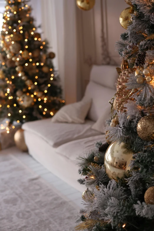 a white couch sitting under a christmas tree next to a window