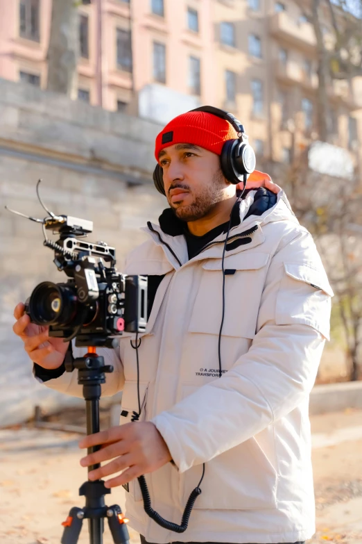 a man holding a camera and wearing headphones