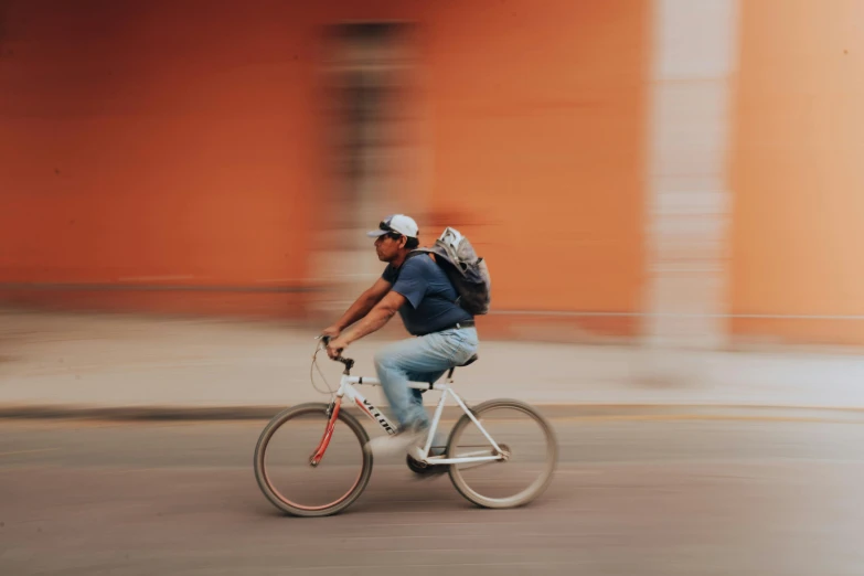 an african american male bicyclist riding down the road